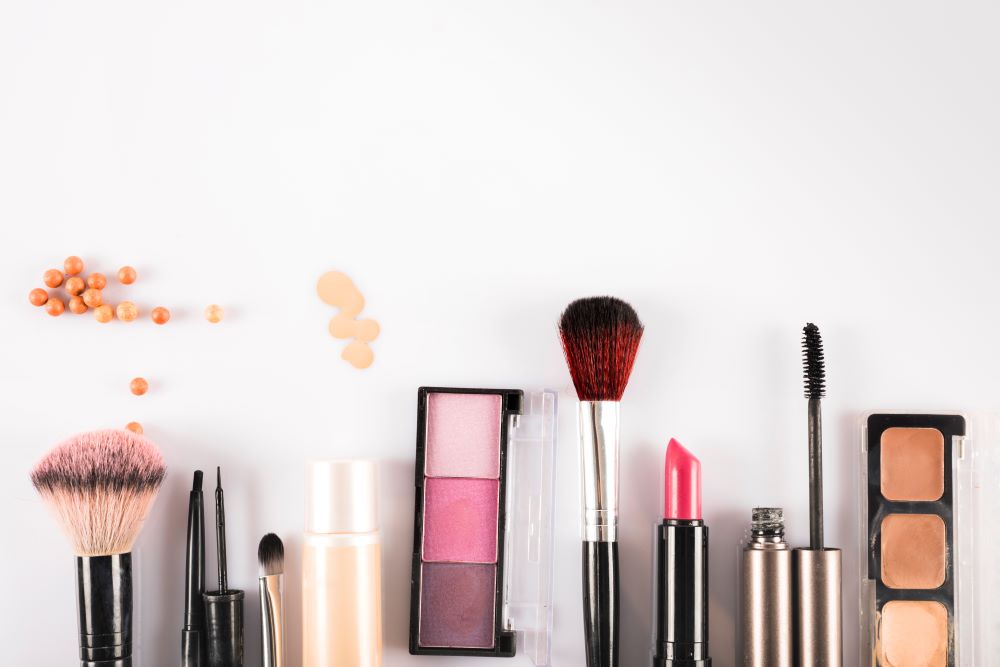 Cosmetics products lay flat on a table, colorful and alluring yet potentially toxic cancer causing products.