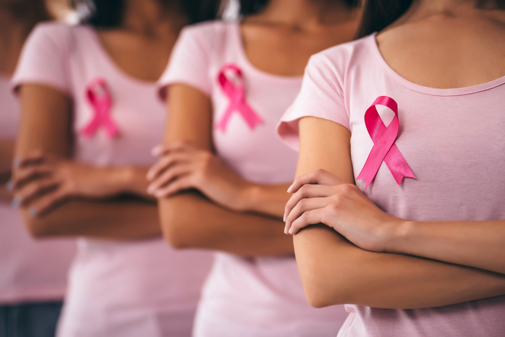 Women wearing pink ribbons for Breast Cancer Awareness Month