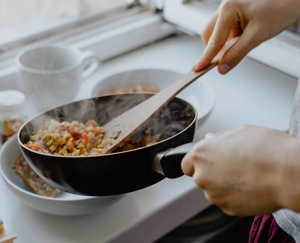A woman cooking a healthy recipe to help fight breast cancer.