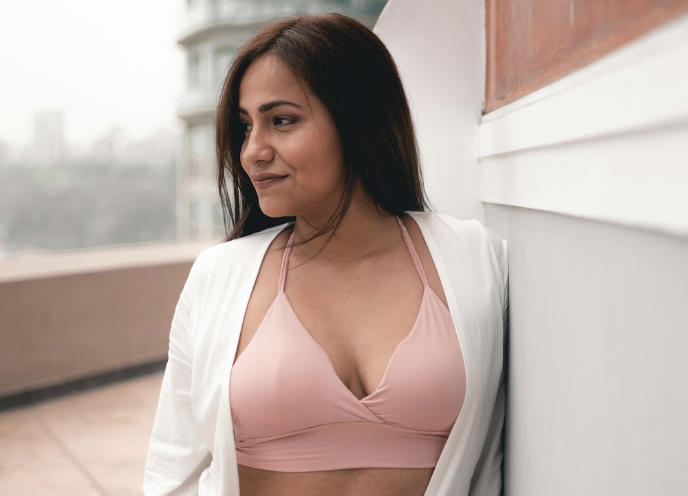 A woman wearing a pink bra for post-op comfort