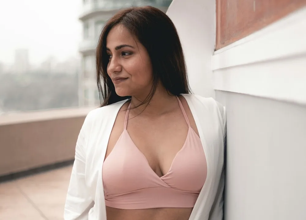 A woman wearing a pink bra for post-op comfort
