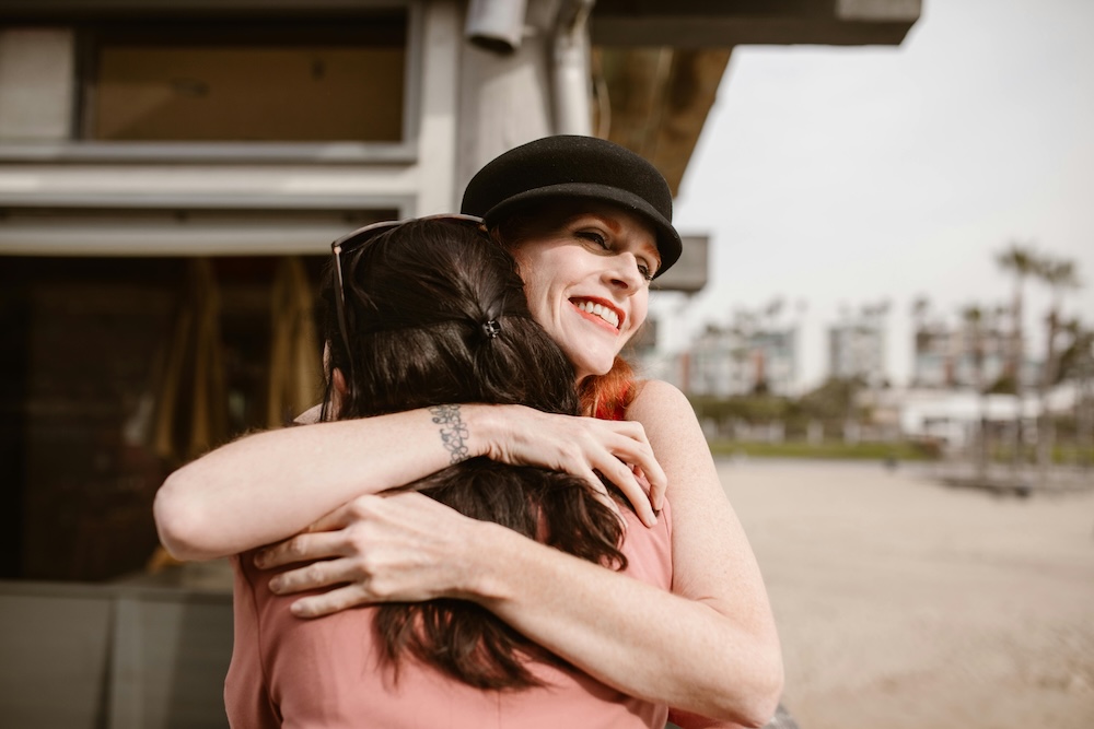 Heartwarming moment of a breast cancer patient embracing a dear friend, sharing joy and support. A touching display of love, resilience, and friendship.