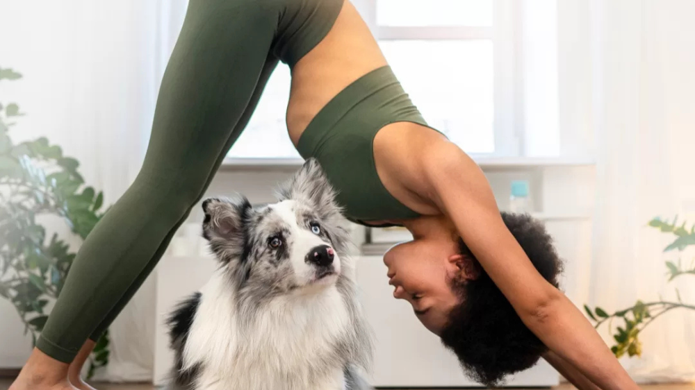 image of a women and her puppy doing yoga together 